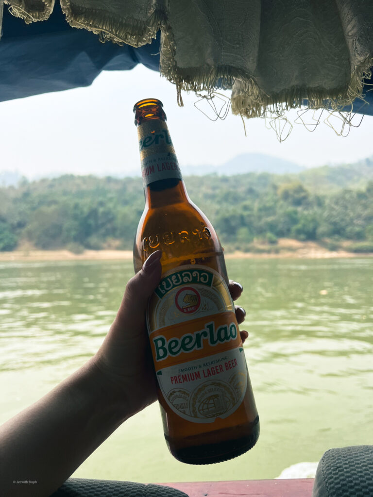 A beerlao in front of a view of the Mekong River 