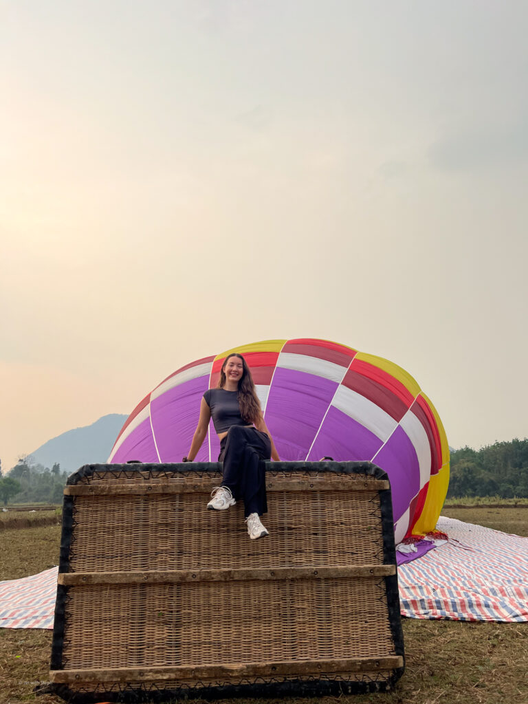 Jet with Steph sat on a hot air balloon basket in Laos