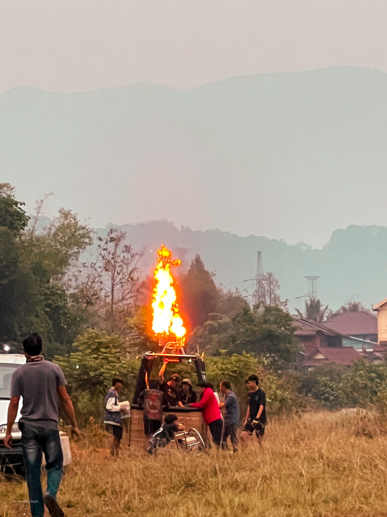 Locals firing up a hot air balloon in Vang Vieng, Laos